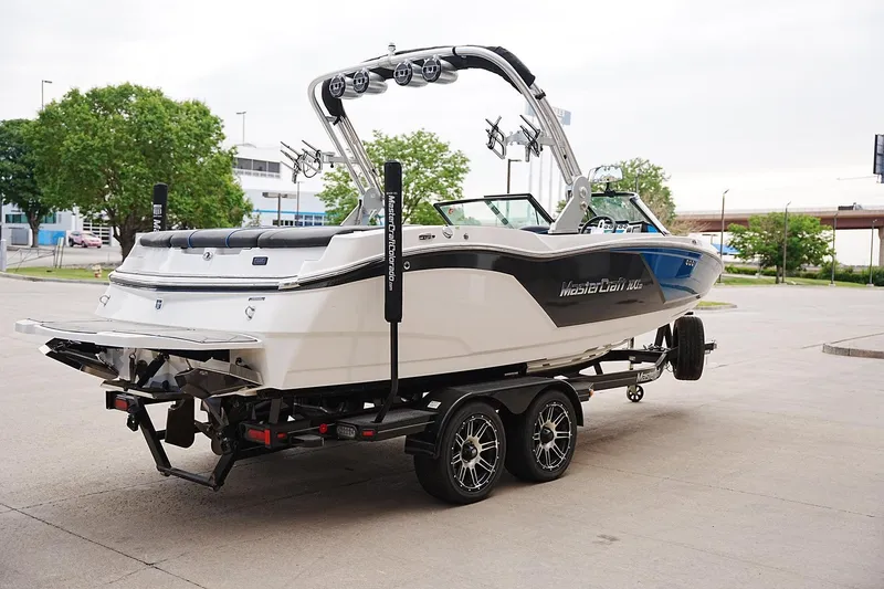 Slide: The Image of 2019 MasterCraft NXT22 boat on trailer, parked outdoors. - 3