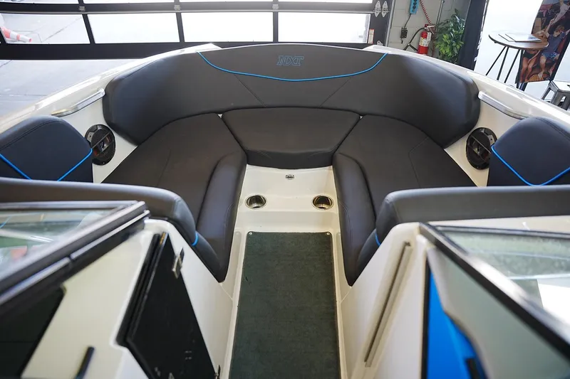 Slide: The Image of 2019 MasterCraft NXT22 boat interior with black seating and blue accents. - 7
