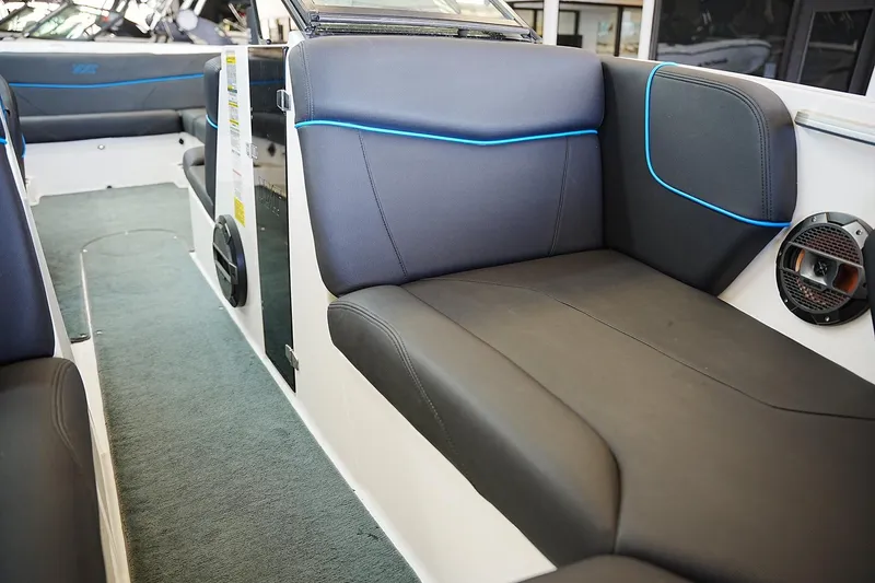 Slide: The Image of 2019 MasterCraft NXT22 boat interior with sleek black seating and blue accents. - 8