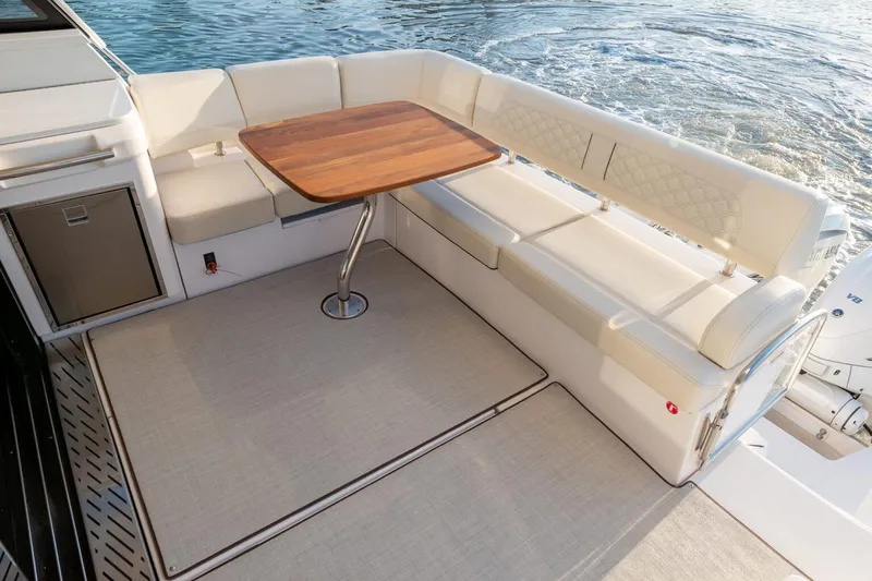 Slide: The Image of Manufacturer Provided Image: Luxurious seating area on 2026 Regal 42 XO yacht with wooden table and ocean view. - 5