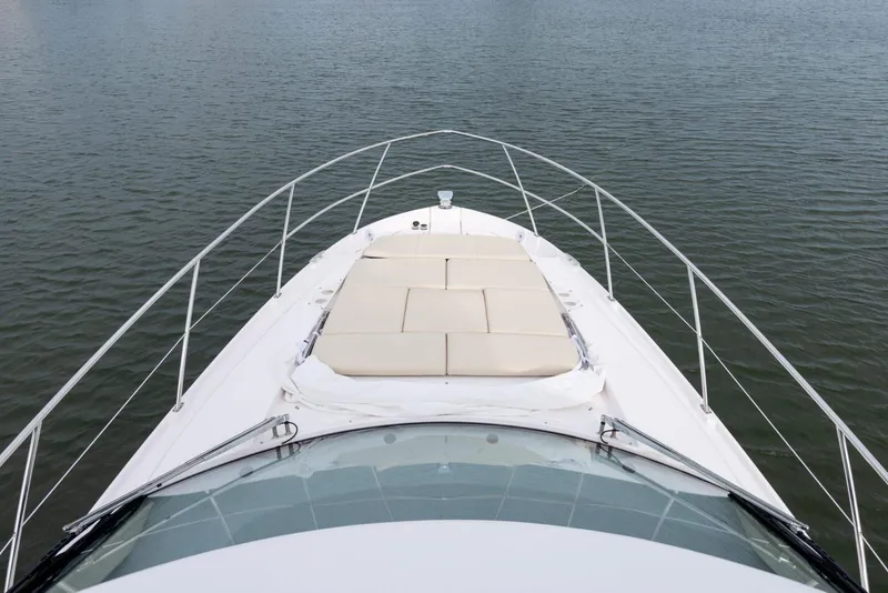 Slide: The Image of Manufacturer Provided Image: 2026 Regal 42 XO yacht bow with sunpad, cruising on calm water. - 6