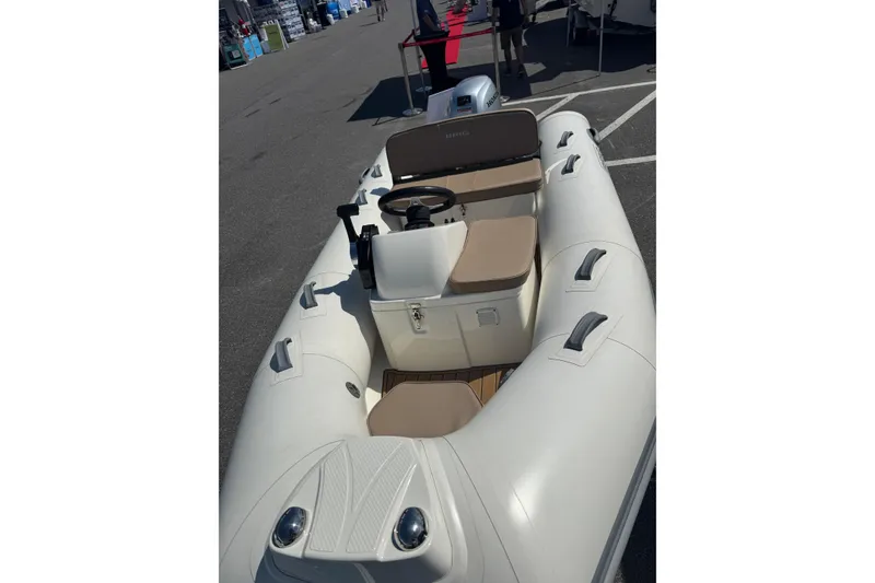 The Image of 2026 Brig Falcon 360 inflatable boat with beige seating and steering console. - 1