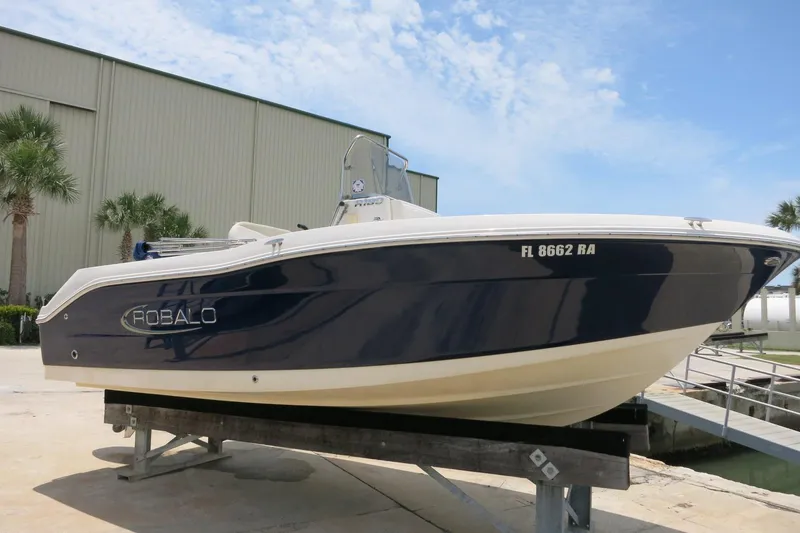 The Image of 2016 Robalo R180 Center Console boat on display, blue hull, docked outdoors. - 0