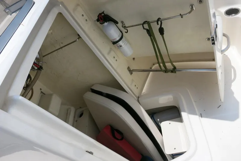 Slide: The Image of 2016 Robalo R180 Center Console boat storage compartment with fire extinguisher and equipment. - 14