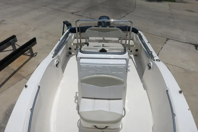 Slide: The Image of 2016 Robalo R180 Center Console boat, white interior, docked on concrete surface. - 18