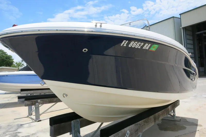 Slide: The Image of 2016 Robalo R180 Center Console boat on display, blue and white hull. - 5