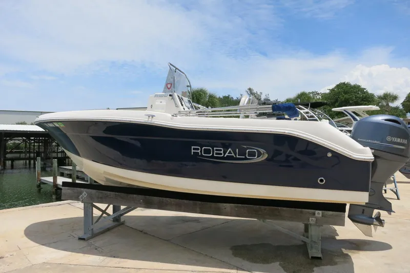 Slide: The Image of 2016 Robalo R180 Center Console boat on a lift, featuring a Yamaha outboard motor. - 6