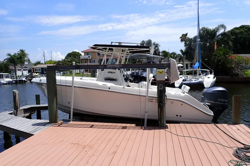 The Image of 2015 Century 2301 Center Console boat docked by waterfront homes. - 0