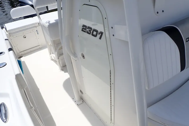 Slide: The Image of 2015 Century 2301 Center Console boat interior with white seating and storage compartments. - 12