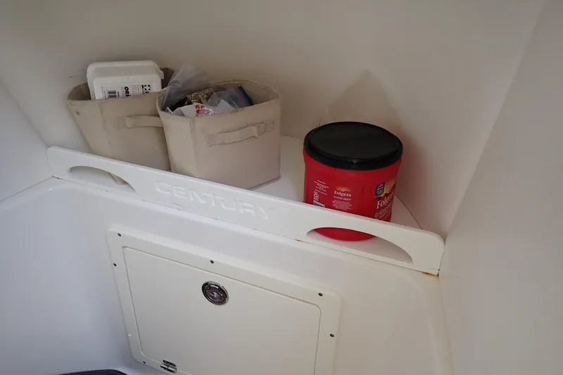 Slide: The Image of Storage area inside a 2015 Century 2301 Center Console boat with containers and a coffee canister. - 14