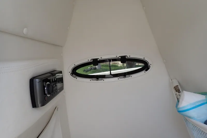 Slide: The Image of Interior view of a 2015 Century 2301 Center Console boat cabin with window and control panel. - 16