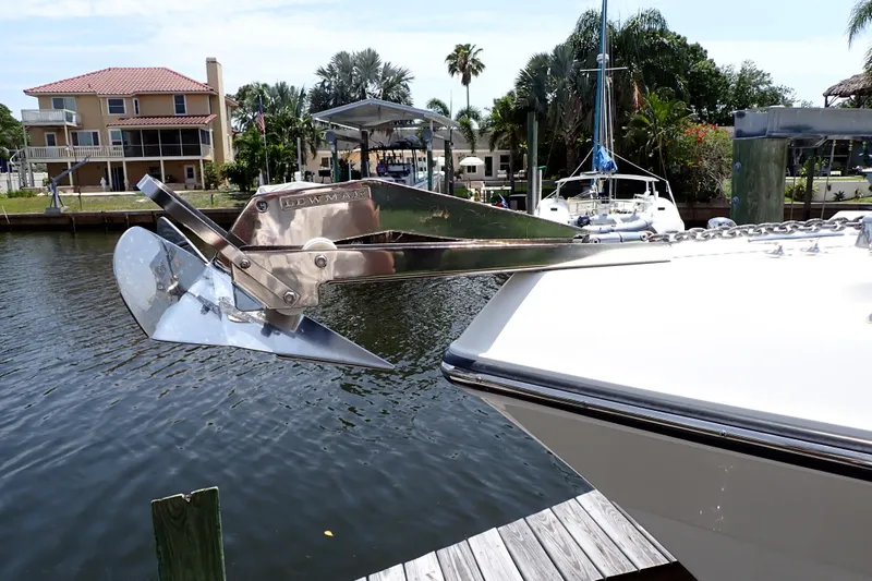 Slide: The Image of Century 2301 Center Console 2015 with Lewmar anchor, docked near waterfront homes. - 2