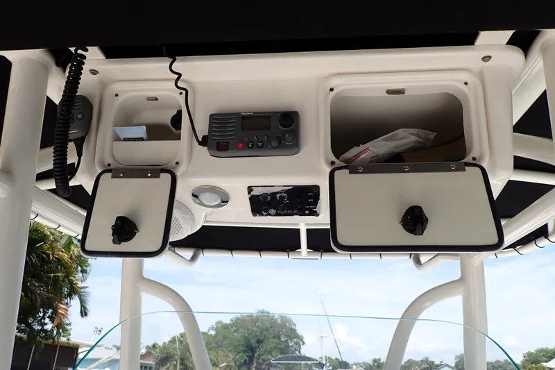 Slide: The Image of 2015 Century 2301 Center Console boat dashboard with storage compartments and radio equipment. - 46