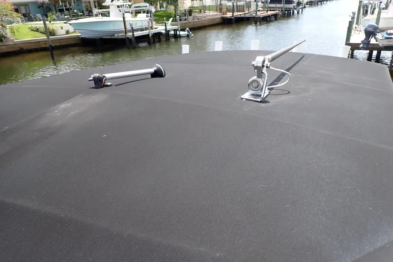 Slide: The Image of 2015 Century 2301 Center Console boat with black canvas cover, docked by a canal. - 58