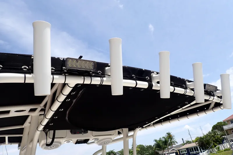 Slide: The Image of T-top rod holders on a 2015 Century 2301 Center Console boat under a clear blue sky. - 59