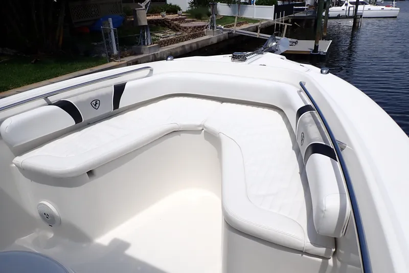 Slide: The Image of 2015 Century 2301 Center Console boat with white cushioned seating, docked by the water. - 8