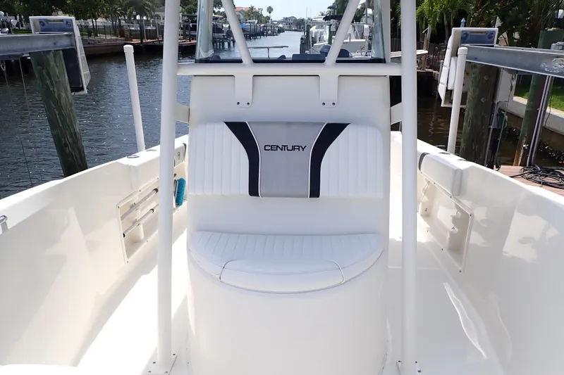 Slide: The Image of 2015 Century 2301 Center Console boat interior with seating, docked by a canal. - 9