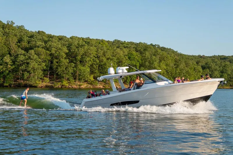 The Image of Manufacturer Provided Image: 2026 Regal 38 Surf boat cruising on a lake with people enjoying water activities. - 0