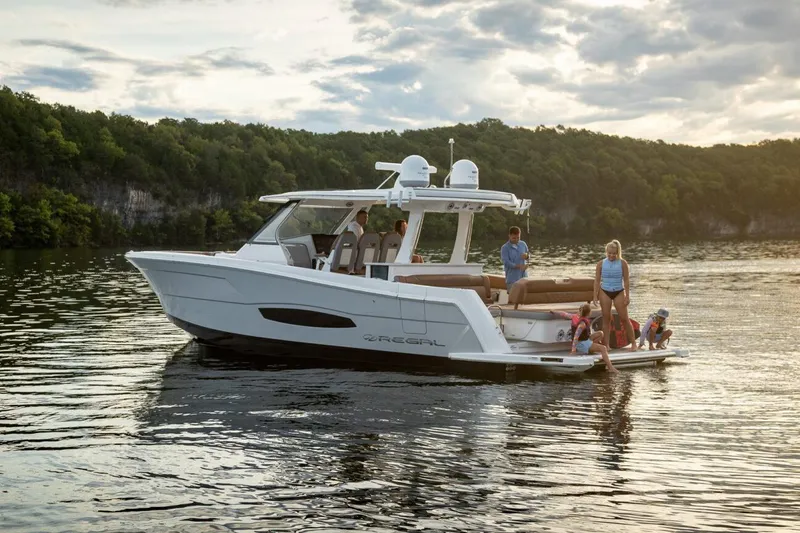 Slide: The Image of Manufacturer Provided Image: 2026 Regal 38 Surf boat on a serene lake with people enjoying the view. - 2