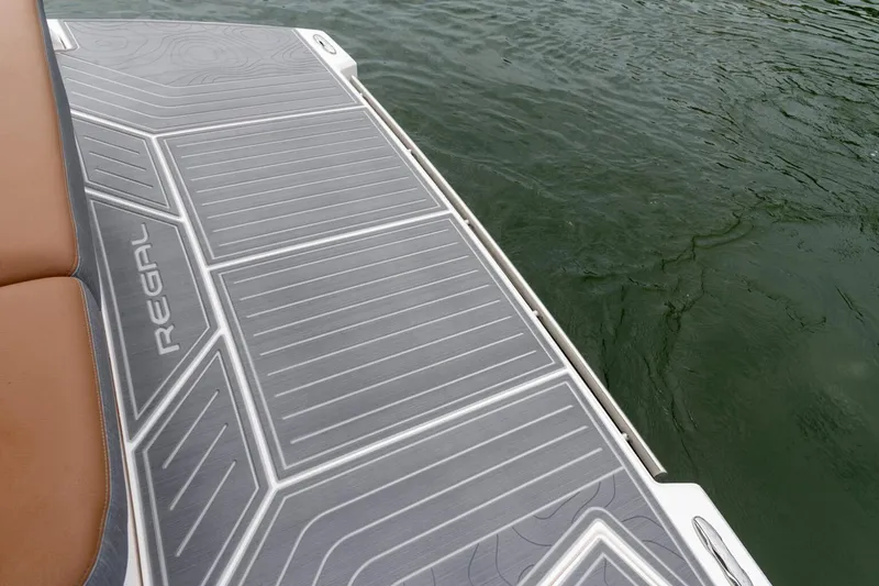 Slide: The Image of Manufacturer Provided Image: 2026 Regal 38 Surf boat deck with sleek design by the water. - 5