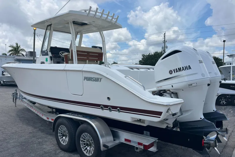 The Image of 2019 Pursuit S 288 Sport boat on trailer with Yamaha engines, parked outdoors. - 1