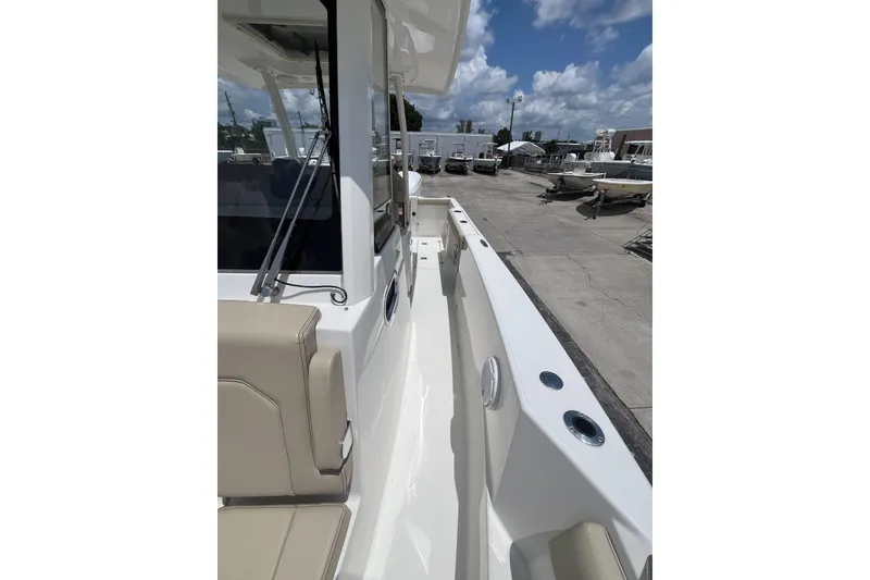 Slide: The Image of 2019 Pursuit S 288 Sport boat deck with beige seating and clear sky. - 10