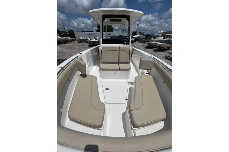 Slide: The Image of 2019 Pursuit S 288 Sport boat interior with beige seating under a blue sky. - 11