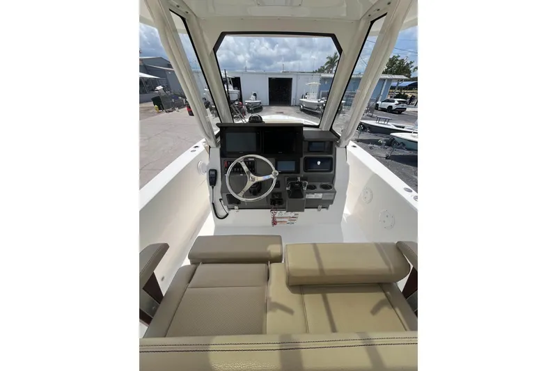 Slide: The Image of 2019 Pursuit S 288 Sport boat helm with steering wheel and navigation controls. - 15