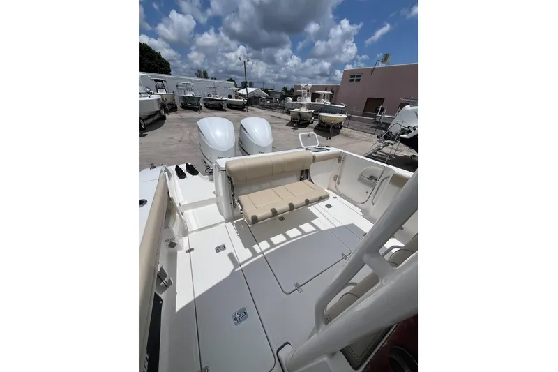 Slide: The Image of 2019 Pursuit S 288 Sport boat with dual engines and seating, docked under cloudy sky. - 17