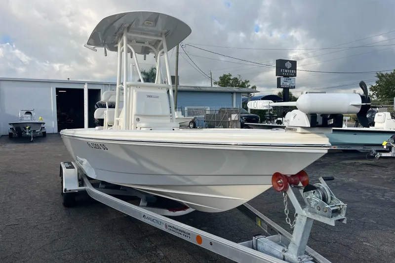 Slide: The Image of 2019 Pursuit S 288 Sport boat on trailer at dealership, cloudy sky background. - 21