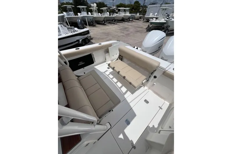 Slide: The Image of 2019 Pursuit S 288 Sport boat interior with beige seating and dual engines. - 25