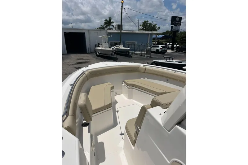 Slide: The Image of 2019 Pursuit S 288 Sport boat with beige seating, docked outdoors under cloudy sky. - 8