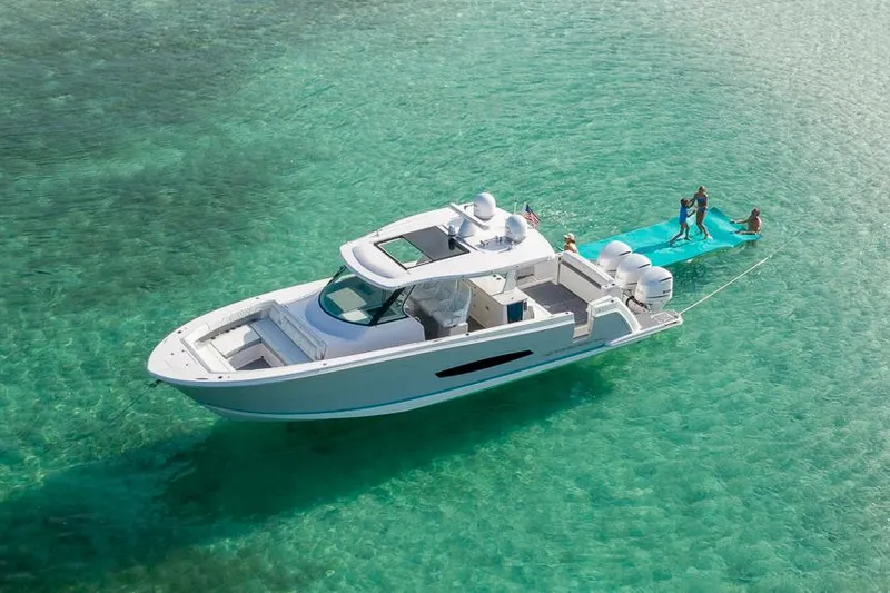 Slide: The Image of Manufacturer Provided Image: 2026 Regal 38 SAV yacht on clear turquoise water with people enjoying water activities. - 2