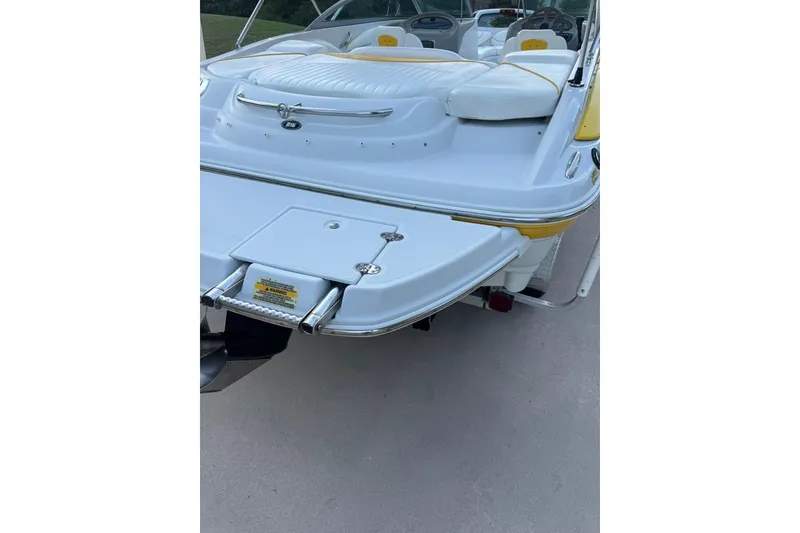 Slide: The Image of 2005 Crownline 210 Razor boat with swim platform and ladder, featuring white and yellow seating. - 13