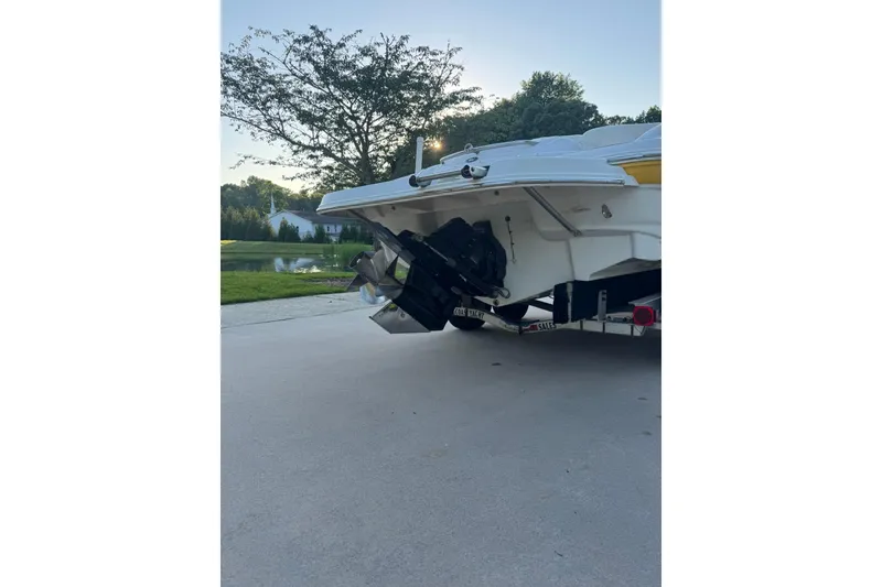 Slide: The Image of Rear view of 2005 Crownline 210 Razor boat on trailer, parked near a pond. - 2