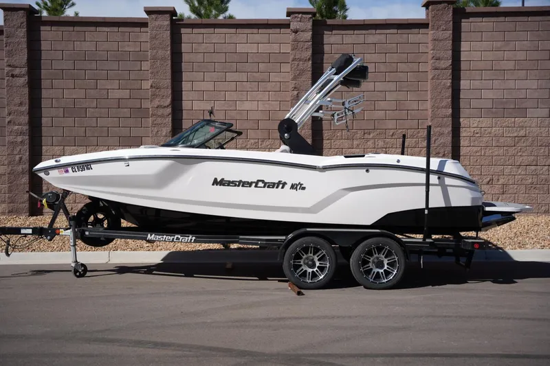 The Image of 2020 MasterCraft NXT20 boat on trailer, parked by brick wall. - 1