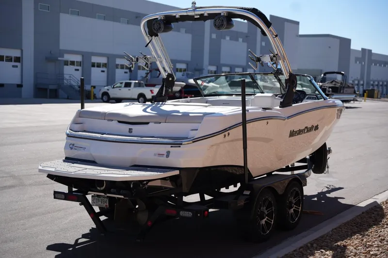 Slide: The Image of 2020 MasterCraft NXT20 boat on trailer in industrial area. - 4