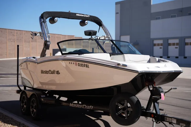 Slide: The Image of 2020 MasterCraft NXT20 boat on trailer in urban setting. - 6