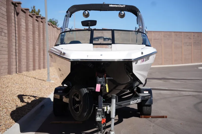 Slide: The Image of 2020 MasterCraft NXT20 boat on trailer, parked on a paved road. - 7