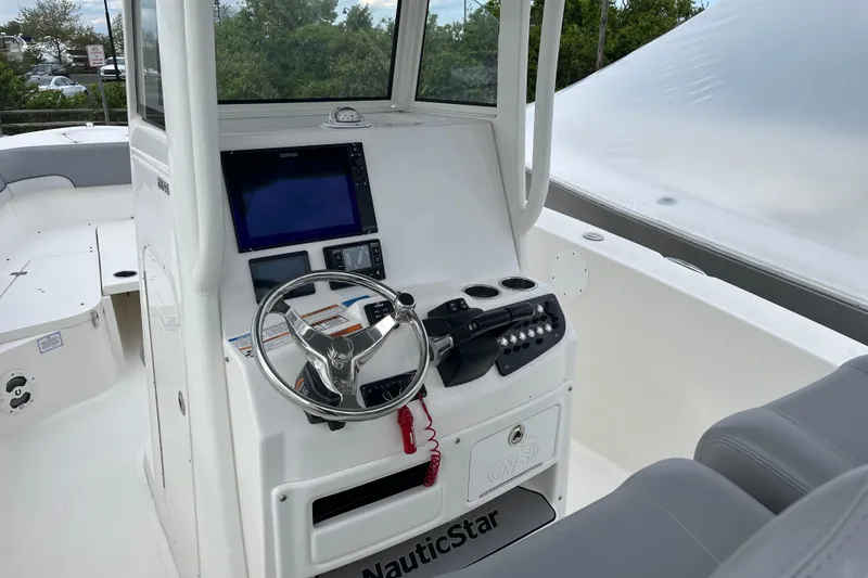 Slide: The Image of 2022 NauticStar 28 XS boat cockpit with steering wheel and navigation controls. - 2