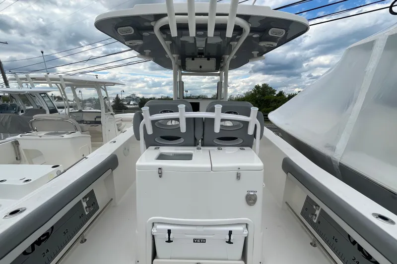 Slide: The Image of 2022 NauticStar 28 XS boat interior with seating and storage under cloudy sky. - 8