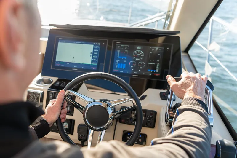 Slide: The Image of Manufacturer Provided Image: Person steering 2026 Regal 38 XO yacht with advanced navigation system. - 16