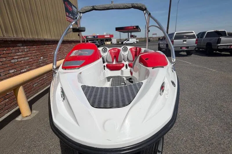 Slide: The Image of 2008 Sea-Doo 150 Speedster boat with red and white interior, parked outdoors. - 6
