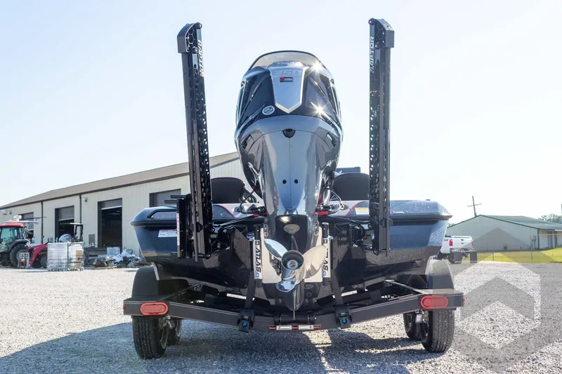 Slide: The Image of 2026 Skeeter ZXE20 boat with powerful outboard motor, parked on gravel near industrial buildings. - 10