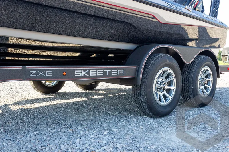 Slide: The Image of 2026 Skeeter ZXE20 boat trailer with dual wheels on gravel surface. - 13