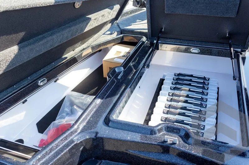 Slide: The Image of Storage compartment of 2026 Skeeter ZXE20 boat with organized fishing rod holders. - 33