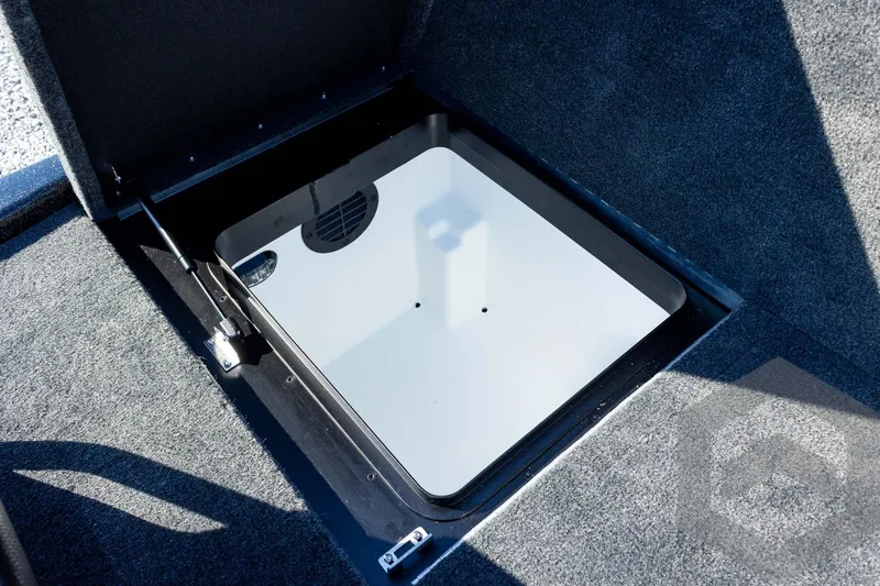 Slide: The Image of Open storage compartment in 2026 Skeeter ZXE20 boat, featuring a sleek, carpeted interior design. - 55