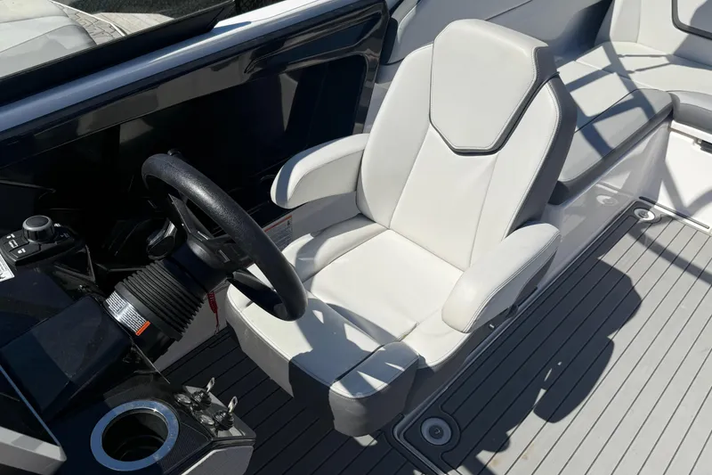 Slide: The Image of 2023 Yamaha Boats AR250 cockpit with steering wheel and white captain's chair. - 13