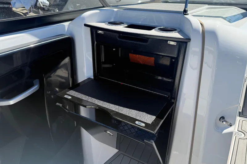 Slide: The Image of 2023 Yamaha Boats AR250 interior storage compartment with cup holders and sleek design. - 25