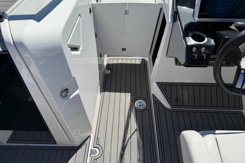 Slide: The Image of 2023 Yamaha Boats AR250 interior with sleek flooring and modern helm design. - 28